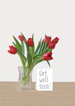 A bunch red tulips in a glass vase and a message on a card that reads 'Get Well Soon'