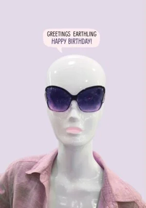 A birthday card featuring an alien in a pink shirt with sunglasses and a somewhat alien head, and a speech bubble with text 'Greetings Earthling - Happy Birthday'